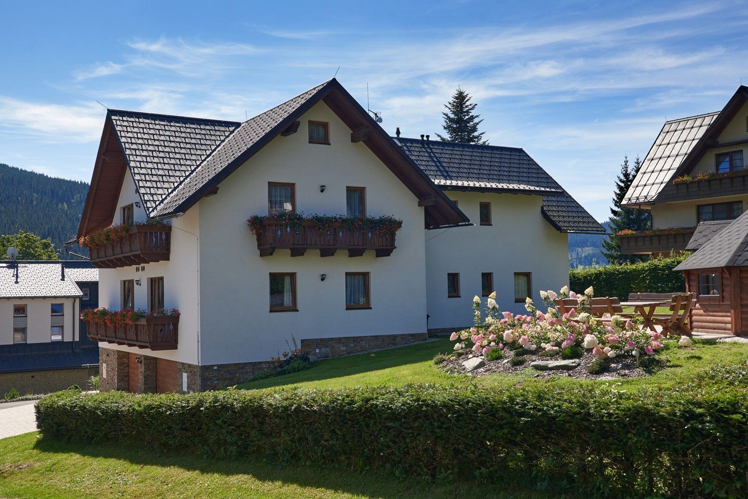 Dokončená dřevostavba se sedlovou střechou a dřevěnými balkony